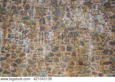 Medieval Cobblestones Wall Made Of Processed Stones In Cement. Antient Architecture Concept. Abstrac