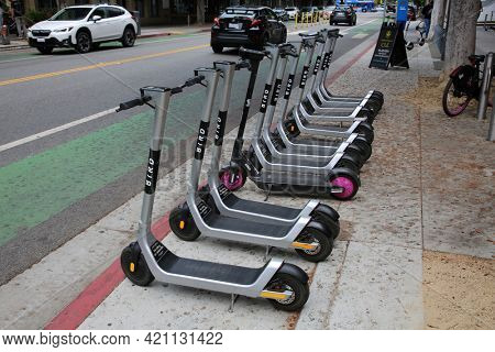 May 14, 2021 Santa Monica California, USA: Bird Electric Scooters Lined Up on a sidewalk waiting to be rented and ridden around by various people. Rental Scooter Business. Editorial Use.