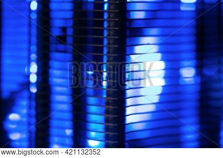 Cooling abstarct. Aluminum Radiator fins of  LED illuminated cooling fan, light coming through the radiator fins.  Cooling fan for computer and PC equipment. Extremely Shallow depth of field.