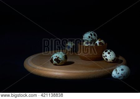 Fresh Quail Eggs Lie On A Wooden Cutting Board Isolated On A Black Background. Culinary Concept