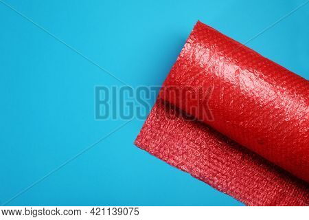 Bubble Wrap Roll On Light Blue Background, Top View. Space For Text