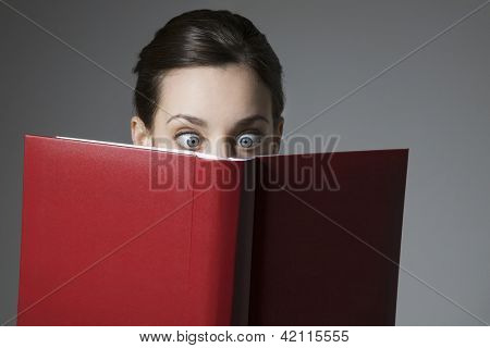 目が開かれた本を読んで驚いたの若い女性