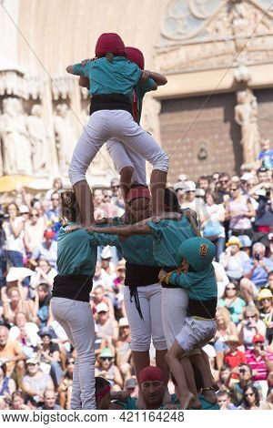 Tarragona, Spain, September 19, 2019 - Children Complete Erection Of Human Castells Tower By Climbin