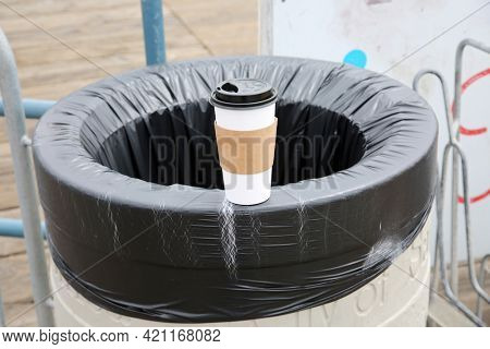 May 14, 2021 Santa Monica California, USA: Generic paper coffee cup on the side of a trash can with a plastic liner. Paper Coffee Cups are used world wide to drink coffee and soda. Editorial Use. 