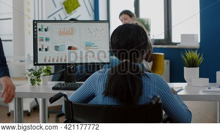 Man Employee Helping His Disabled Immobilized Black Colleague Entering In Business Office Pushing Wh