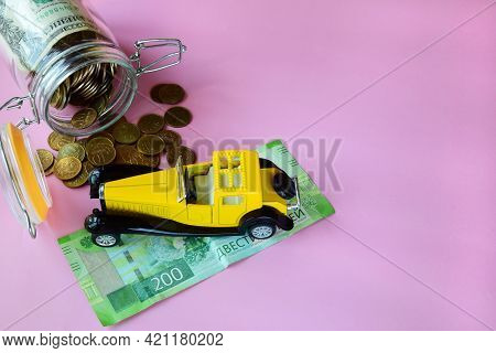 Yellow Toy Car On The Banknote And Manets. Concept Of Auto Insurance And Finance For The Purchase Of