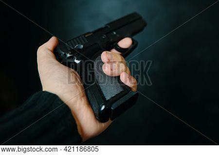 Criminal Holding Pistol On Dark Background. First Person View Of Gun. Firearm In Mans Hand. Defense 