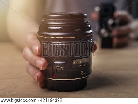 Photographer Showing Camera Lens, Blurred Vintage Old One And Modern 85 Mm Portrait Lens.
