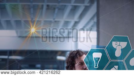 Spot of light and multiple medical icons against male doctor examining x-ray report at hospital. healthcare and medical professionalism concept