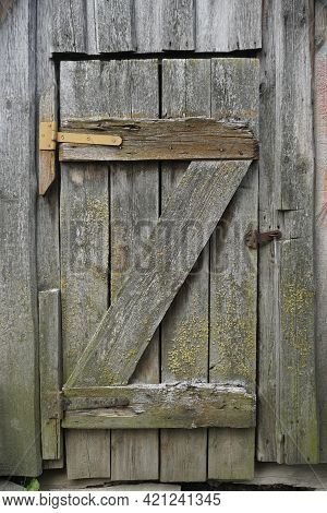 The Door From The Boards To The Cellar. Retro. Old Awnings And Rusty Nails. Vertical Shot