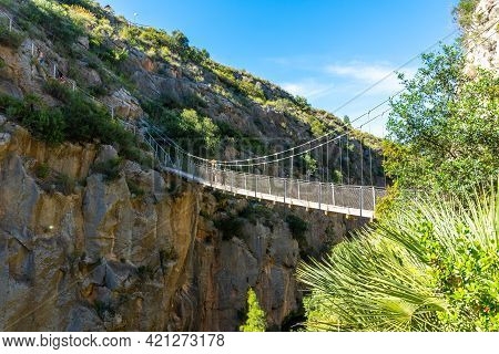 A Young Girl Crossing The Wooden Suspension Bridges. Ruta De Los Pantaneros In The Town Of Chulilla 