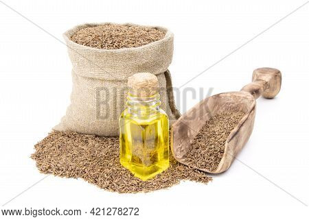 Cumin Essential Oil. Glass Bottle Of Cummin Oil. Caraway In A Sack Of Isolated On A White Background