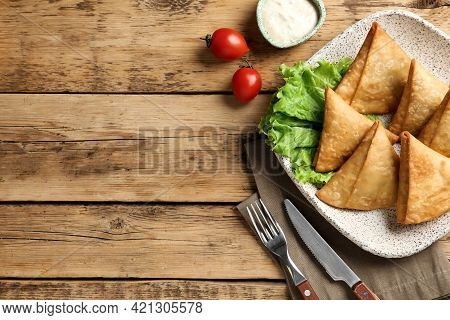 Fresh Delicious Crispy Samosas Served On Wooden Table, Flat Lay. Space For Text