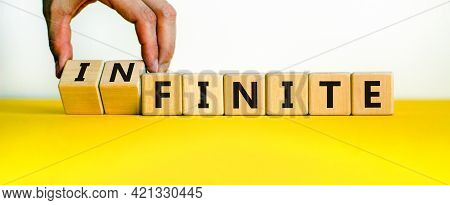 Finite Or Infinite Symbol. Businessman Turns Wooden Cubes And Changes The Word 'finite' To 'infinite