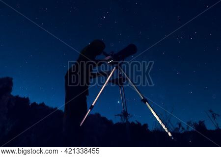 Dark Silhouette Of A Sky Watcher Of The Starry Sky In A Telescope. Woman Observer Watching The Night