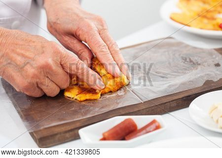 Senior Woman Preparing A Traditional Dish From El Valle Del Cauca In Colombia Called Aborrajado