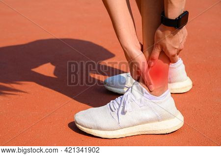 Cropped Shot Of Woman Runner Suffering From Ankle Pain. Ankle Pain May Be Caused By An Injury, Like 