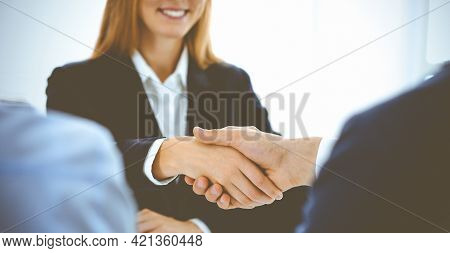Businesspeople Or Lawyers Shaking Hands Finishing Up A Meeting In Blue Toned Office , Close-up. Succ