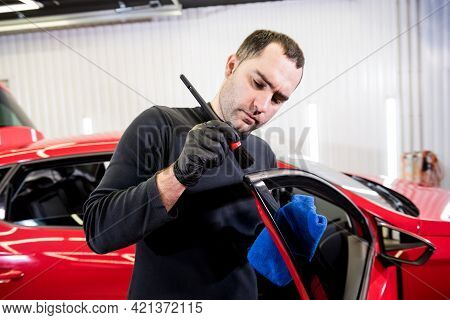 Car Service Worker Cleans Interiror With Special Brush