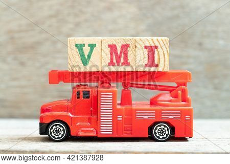 Fire Ladder Truck Hold Letter Block In Word Vmi (abbreviation Of Vendor Managed Inventory) On Wood B