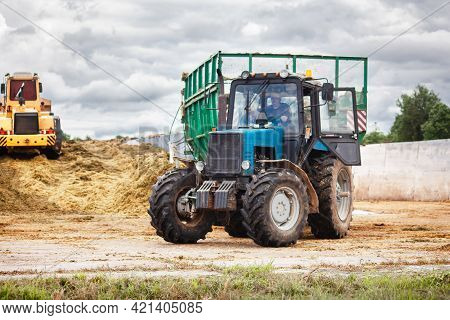 Belarus, Vitebsk, July 2020. A Tractor And A Bulldozer Compact The Cut Grass In A Silage Trench On A