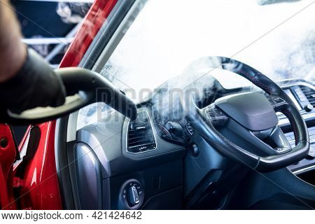 Car Service Worker Cleans Interiror With Steam Cleaner