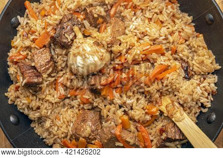 Pilaf Close-up. Oriental Cuisine Concept. National Uzbek Pilaf With Meat In A Cast Iron Pan. Top Vie