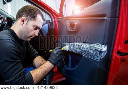 Car Service Worker Cleans Interiror With Special Brush