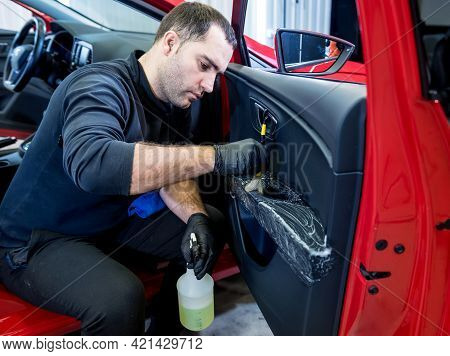Car Service Worker Cleans Interiror With Special Brush