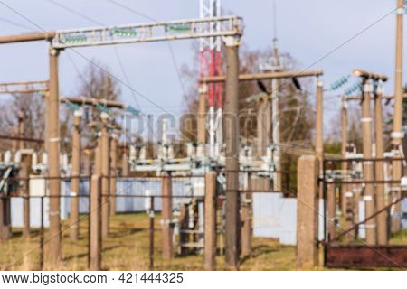 Blurry Image Rows Of Electrical Equipment In Switchyard.electric High Voltage On Blue Sky