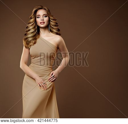 Beauty Woman With Shiny Wavy Curly Hairstyle. Long Blond Hair Model In Beige Shapewear Dress Luxury 