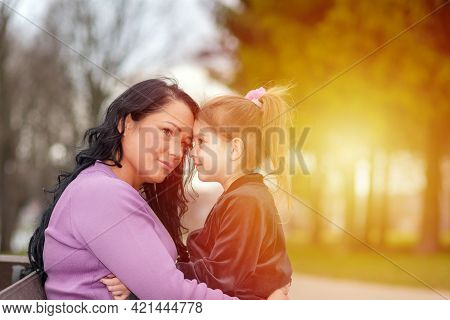 One Lonely Upset Mother Touching With Foreheads With Daughter, At Sunset Park Outdoors.summer Sun Ev