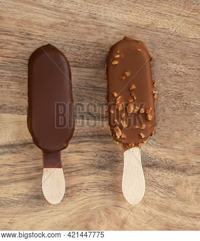 Stick Ice Cream On A Wooden  Background. Vanilla Eskimo Ice-cream Bar. Popsicle And Lolly Sweet Dess
