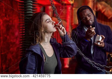 Drug addict man and woman smokes in shebang