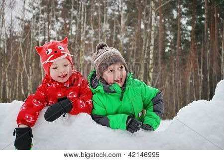 Krásný chlapec a dívka v zimě zasněžený les.