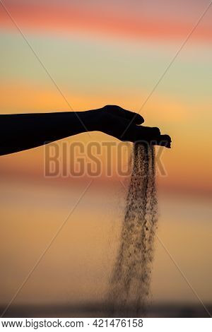 Close Up Of Sand Pouring From The Hand On The Beach On A Sunny Summer Day. Playing With Sand On Vaca