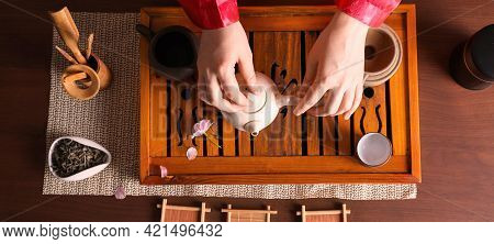 Master Preparing For Traditional Tea Ceremony At Wooden Table, Top View. Banner Design