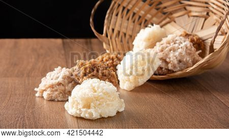 Cocada, Coconut Candy From Brazil, White And Brown Cocadas Fallen From A Straw Basket On Wooden Surf
