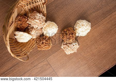Cocada, Coconut Candy From Brazil, White And Brown Cocadas Fallen From A Straw Basket On Wooden Surf
