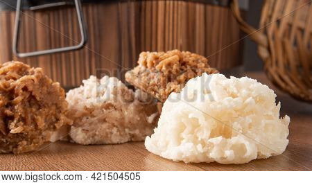 Cocada, Coconut Candy From Brazil, White And Brown Cocadas Fallen From A Straw Basket On Wooden Surf