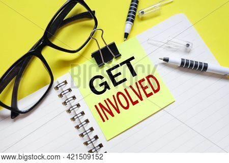Get Involved. Text On Bright Yellow Sticker. On The Blanket. Yellow Background And Black Glasses Nea