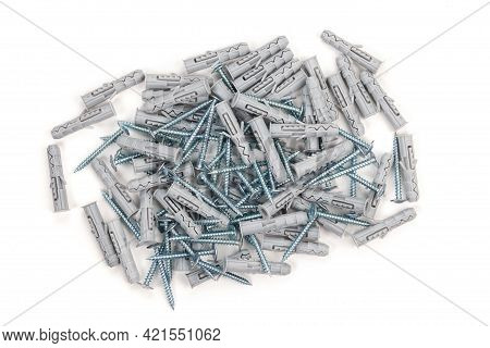 Close Up Isolated Image Of Sets Of Grey Plastic Dowels Plugs And Shiny Metal Self-tapping Screws In 