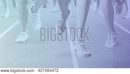 Composition of low section of runners racing on racing track with purple tint. sport, fitness and active lifestyle concept digitally generated image.