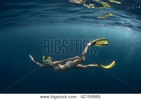 Unterwasser Shooting einer jungen Dame, Tauchen auf einen Atem halten in einem klaren tiefen Meer mit Sonnenstrahlen shini