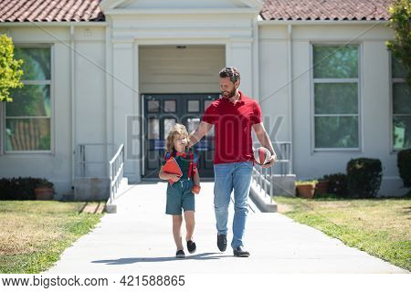 Father Walking Son To School. Parent And Pupil Of Primary School Schoolboy. Dad And Cild Go Beginnin