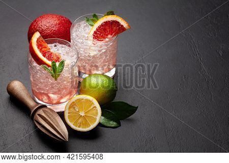 Fresh citrus lemonade with mint and crushed ice. Bood orange, lime, lemon and juicer. With copy space