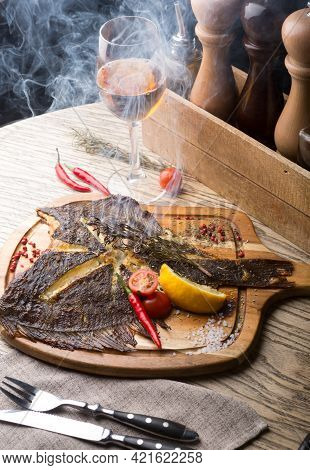 Fried Fish Served On Wooden Board With Glass Of White Wine
