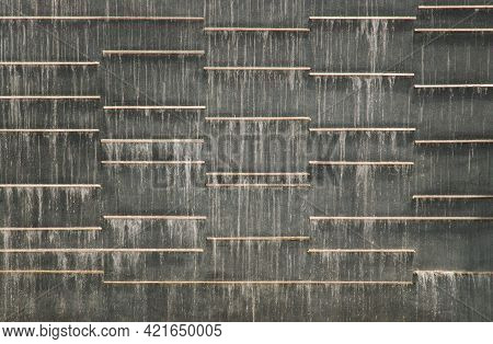 A Low Waterfall Flowing Through Black Stone Slabs. For Background Or Texture, Selective Focus.