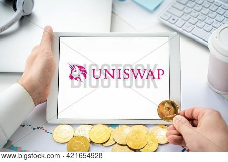 Russia Moscow 06.05.2021.businessman With Tablet.logo Of Cryptocurrency Stock Exchange Uniswap.tradi