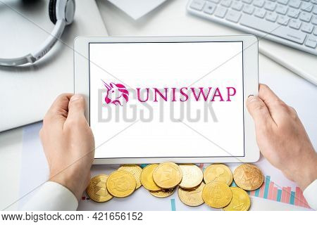 Russia Moscow 06.05.2021.businessman With Tablet.logo Of Cryptocurrency Stock Exchange Uniswap.tradi